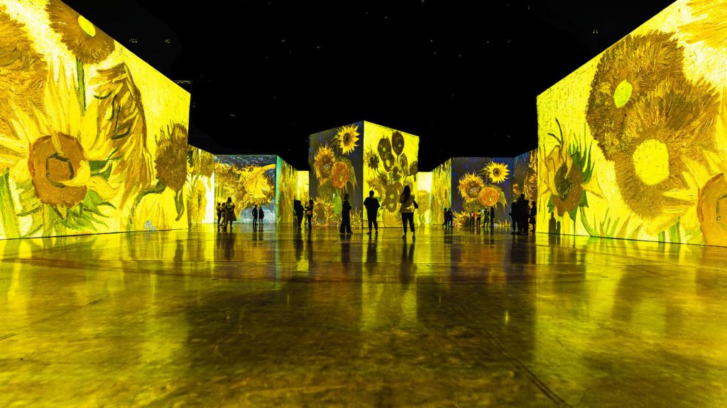 Posjetioci u velikom prostoru savremene imersivne izložbe sa projekcijama svjetla i slike na zidovima