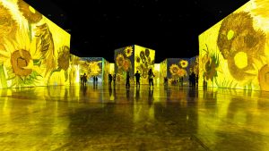 Posjetioci u velikom prostoru savremene imersivne izložbe sa projekcijama svjetla i slike na zidovima